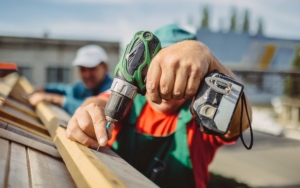 Close up of roofing working drilling in a screw